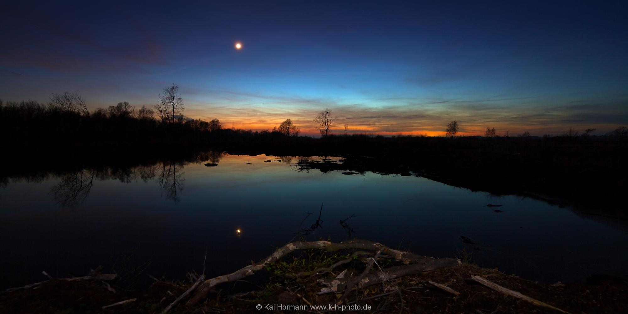 Landschaftspanorama Zwischen Tag und Nacht. Monduntergang über dem Moor.